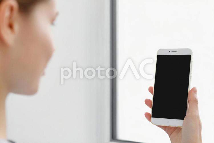 女性の横顔とスマホ画面 スマートフォン,持つ,画面の写真素材