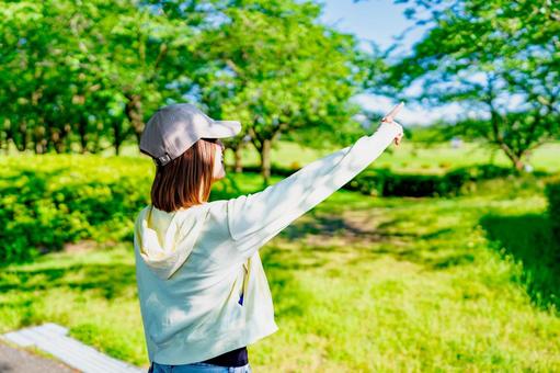 散歩中に空に向かって指を差す女性 散歩中に空に向かって指を差す女性 空,指差し,ダイエットの写真素材