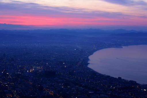 函館山から眺める朝焼けの函館市街と海 函館山から眺める朝焼けの函館市街と海の写真