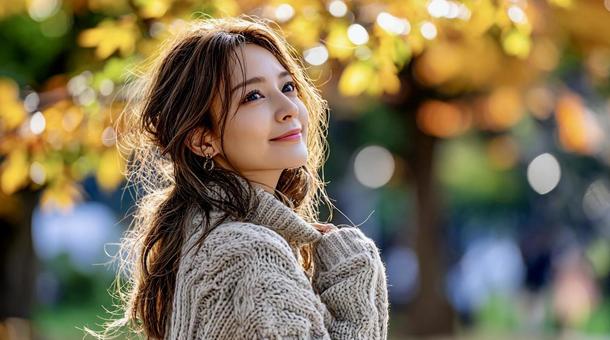 紅葉を背景に微笑む上品な若い女性 紅葉を背景に微笑む上品な若い女性の写真