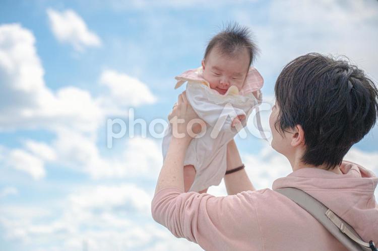 青空と親子(その２) 赤ちゃん,抱っこ,夏の写真素材