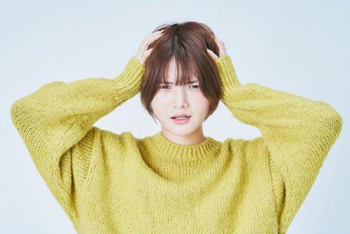 頭を抱えるショートカットの女性 頭を抱えるショートカットの女性 女性,ストレス,辛いの写真素材