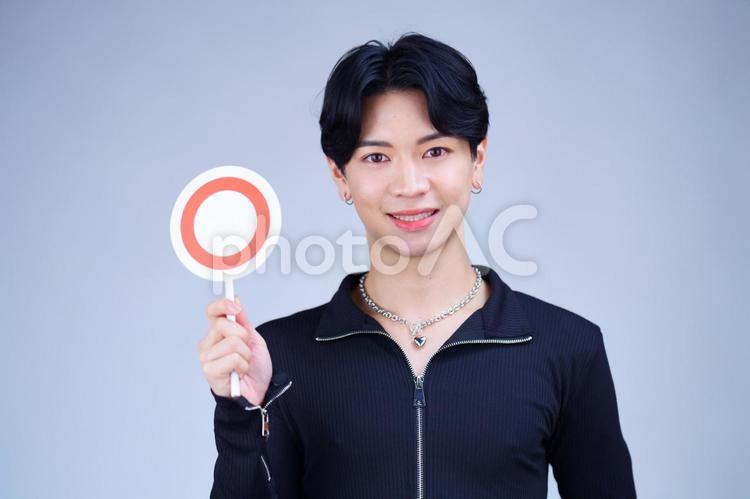 まるプレートを持つ笑顔の男性 男性,クイズプレート,クイズの写真素材