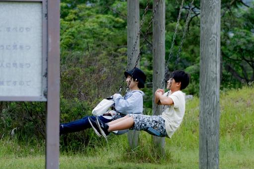 <素材>夏の公園でブランコで遊ぶ親子 <素材>夏の公園でブランコで遊ぶ親子 女性,子供,男性の写真素材