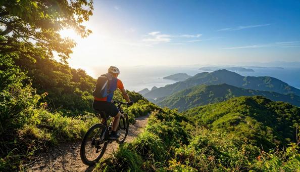 休日に海辺をサイクリングする男性の写真