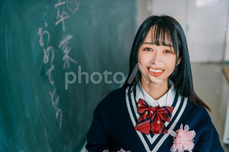 コサージュをつけて笑う笑顔の女子高生 女性,女子高,高校生の写真素材
