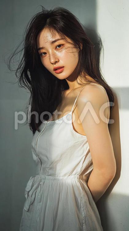 白いワンピースを着た、風になびく髪の女性 女性,20代,ドレスの写真素材