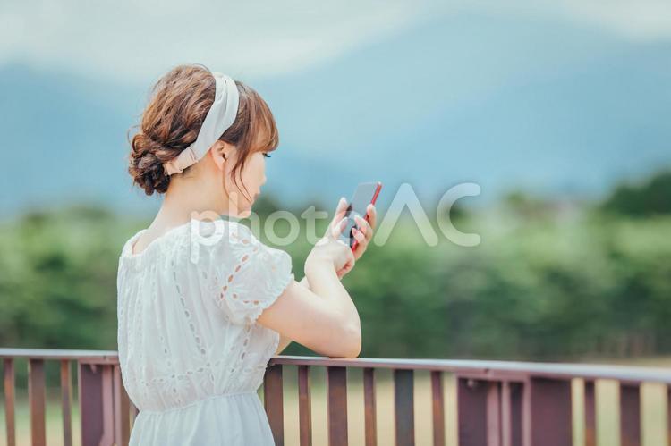 自然の中でスマホを持つ女性 スマホ,携帯電話,アプリの写真素材