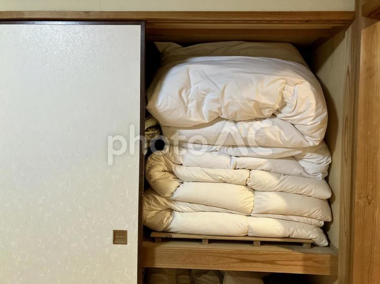 旅館の押し入れに綺麗に畳まれた布団 押し入れ,押入れ,掛け布団の写真素材