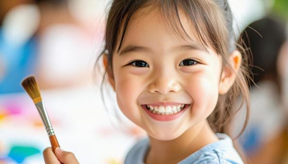 ペインティング中の日本人の子どもの笑顔 ペインティング中の日本人の子どもの笑顔の写真