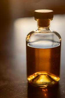 逆光に輝く洋酒ボトル_縦 ウィスキー,ボトル,洋酒の写真素材