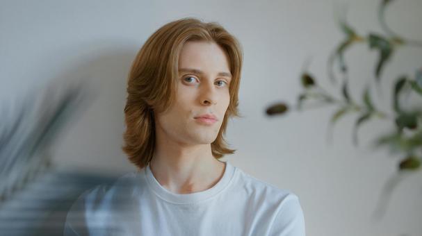 壁にもたれる白いTシャツを着たカメラ目線の男性 男性,外国人,欧米人の写真素材