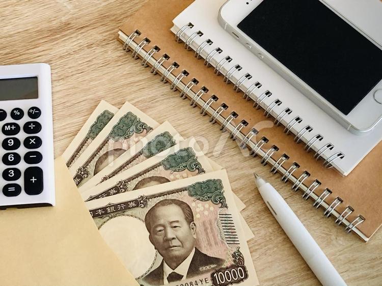 封筒に入った現金と電卓とスマホ・家計簿 お金,マネー,現金の写真素材