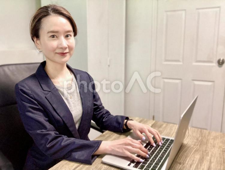 在宅ワークを楽しむスーツの女性 女性,笑顔,集中の写真素材