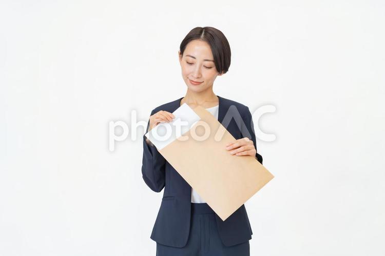 書類を持つスーツを着た女性 確定申告,契約,女性の写真素材