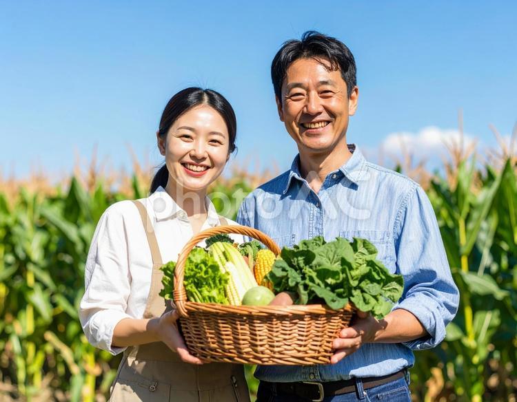 収穫した野菜を手に笑顔の農家夫婦 農家,野菜,収穫の写真素材