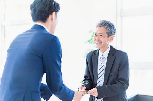 名刺交換をするビジネスマン 仕事,訪問,取引先の写真素材