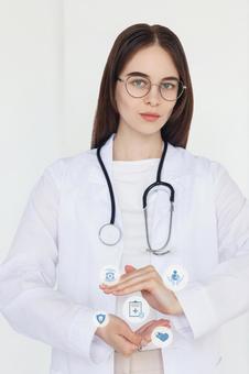 手のひらでジェスチャーする聴診器をつけた眼鏡の女性スタッフ　CG 医療,予防,保険の写真素材