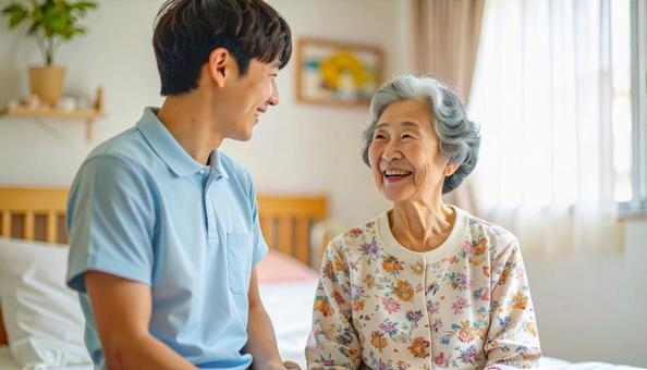 笑顔で話をする男性介護士と高齢女性の写真