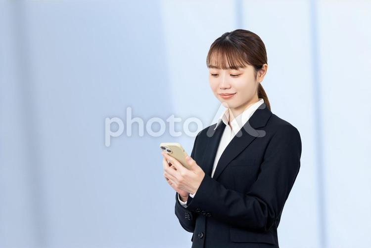 スマホを操作する笑顔のビジネスウーマン 女性,ビジネス,仕事の写真素材