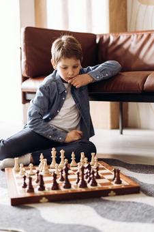男の子が床に座ってチェスをしている 男の子が床に座ってチェスをしている チェス,子ども,男の子の写真素材