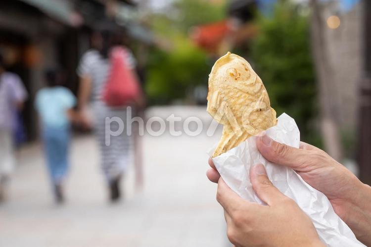 たい焼き手にとる男性　Japan たいやき,手元,指先の写真素材