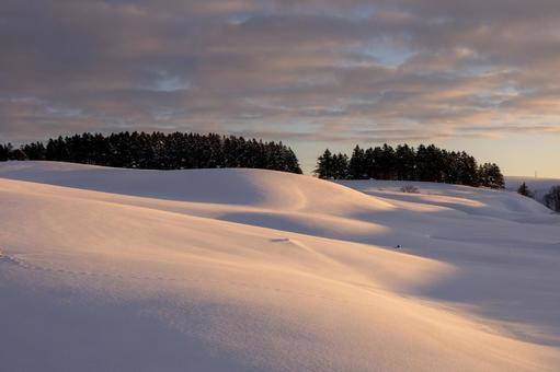 朝焼けが染める、静けさが満ちた冬の丘 丘,雪原,光の写真素材