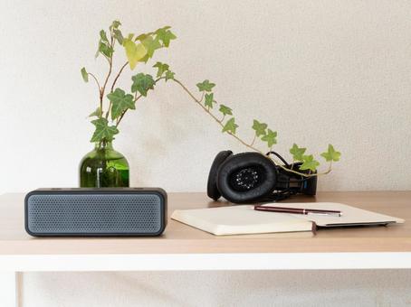 机の上のノートとペンとヘッドホン ノート,ペン,ポータブルスピーカーの写真素材