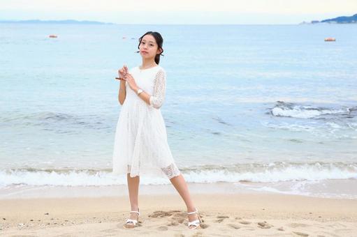 砂浜を背景にこちらを見る女性 女性,海岸,秋の写真素材