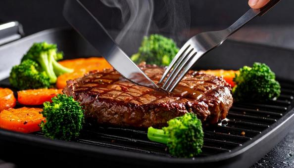 熱々のハンバーグを切って肉汁が出ている 熱々のハンバーグを切って肉汁が出ているの写真