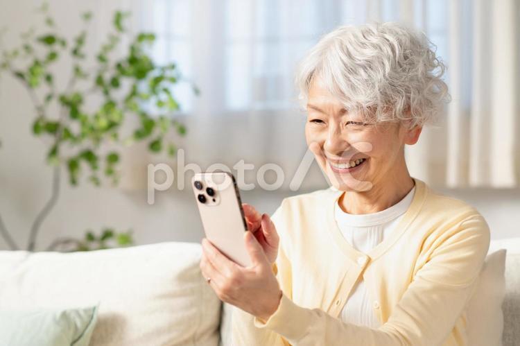 リビングでスマホを使うシニア女性 シニア,女性,人物の写真素材