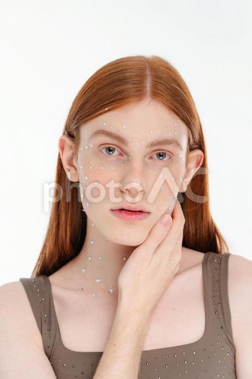 顔にラインストーンを貼ったカメラ目線の女性 女性,ラインストーン,メイクの写真素材