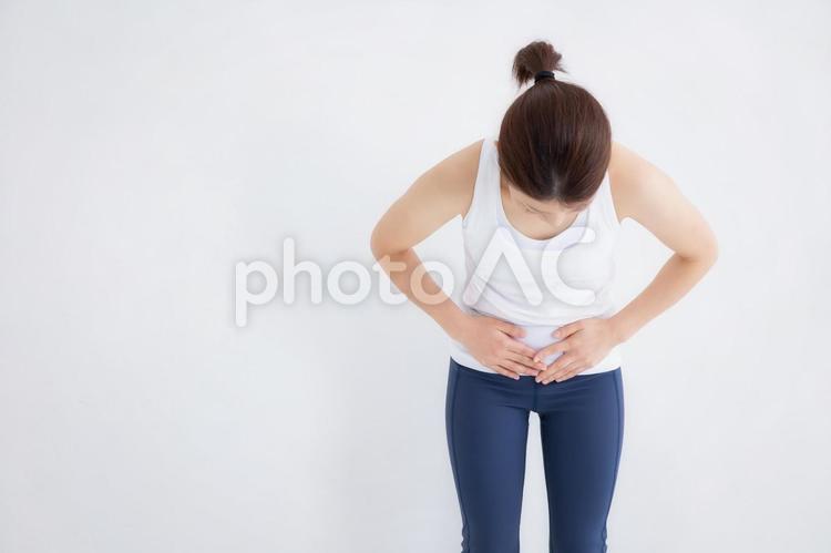 スポーツウェアの女性 腹痛,痛い,お腹の写真素材
