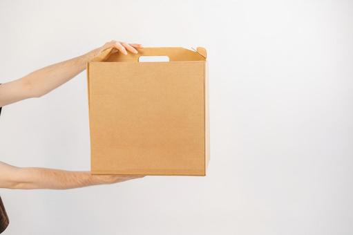 手提げギフト箱を持つ手 配達,フードデリバリー,テイクアウトの写真素材