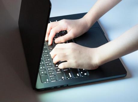 暗闇でノートパソコンのキーボードを打つ指 指,キーボード,ノートパソコンの写真素材