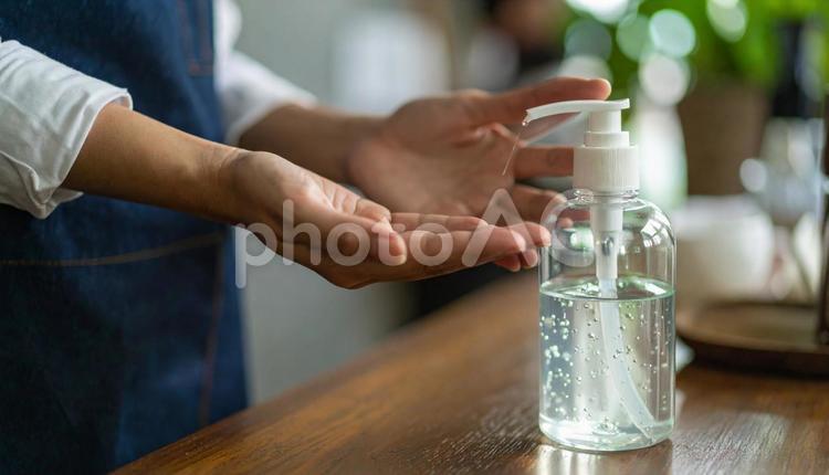 ポンプを押して消毒液を出して消毒する手 喫茶店,消毒,消毒液の写真素材