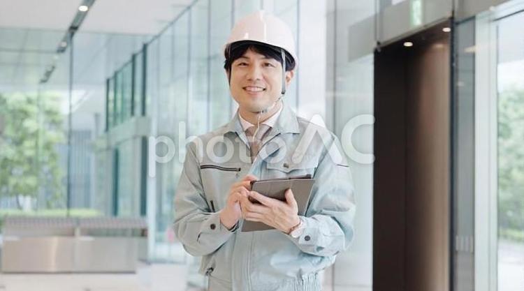  笑顔で働く作業服を着た男性 作業員,男性,作業服の写真素材