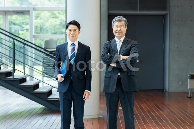 オフィスの廊下に立つビジネスパーソン ビジネスマン,笑顔,ビジネスパーソンの写真素材