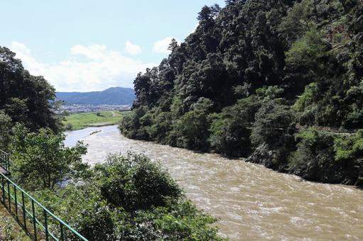 山の間の濁流の流れる川と町と山と空の風景 山の間の濁流の流れる川と町と山と空の風景 間,濁流,流れの写真素材