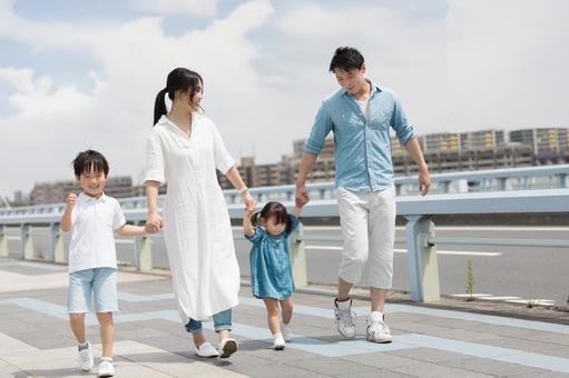 手を繋いで屋外を散歩する親子 手を繋いで屋外を散歩する親子 人物,家族,女性の写真素材