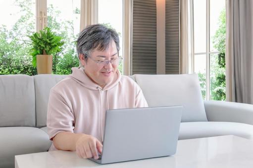 自宅で作業する男性 自宅で作業する男性 男性,パソコン,ノートpcの写真素材