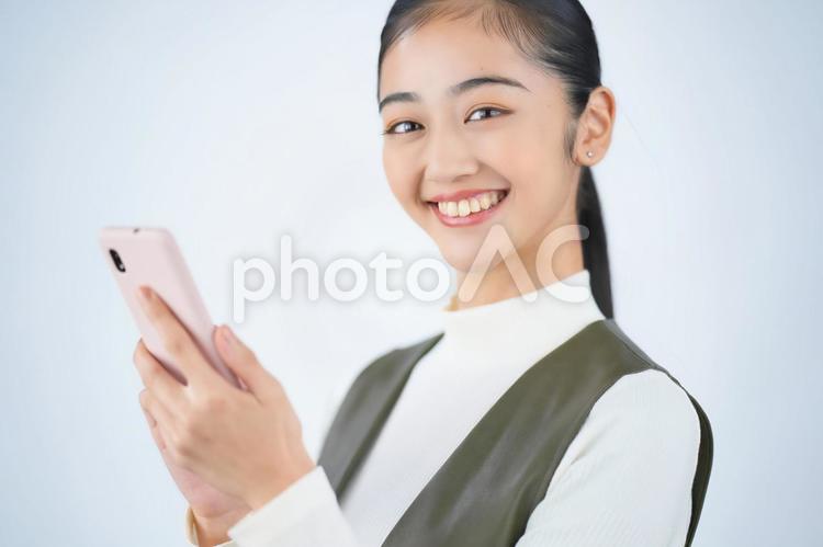 スマホを使う女性（白背景） 女性,日本人,１人の写真素材