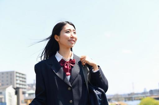 日本の女子高生が青空の下で笑顔で通学する 日本の女子高生が青空の下で笑顔で通学する 高校生,女子学生,学生の写真素材