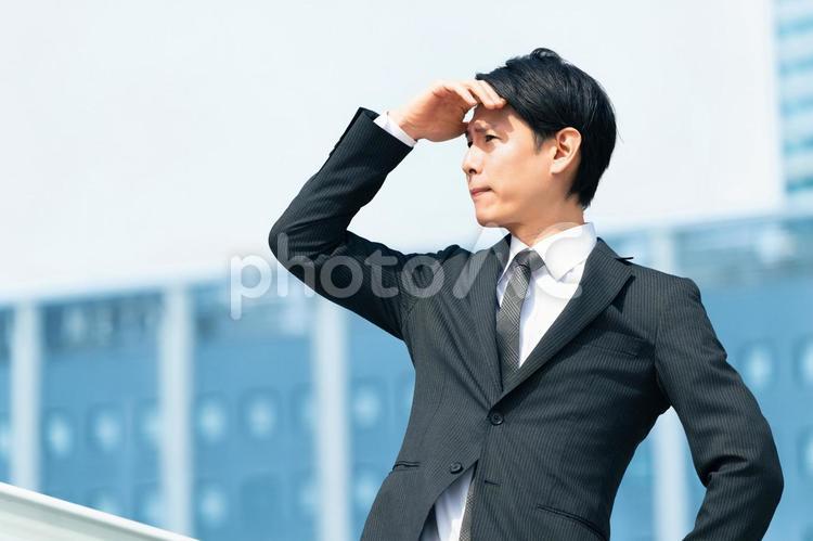 日差しを手で遮る男性ビジネスマン 男性,夏,暑いの写真素材