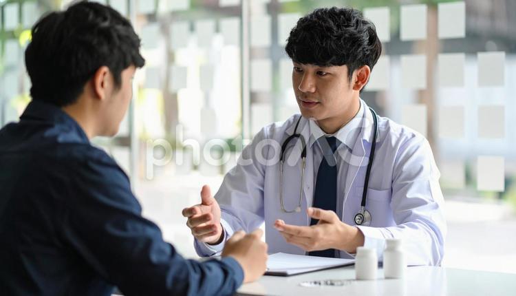 患者に対して簡単な服薬指導を行う男性医師 製薬会社,処方,漢方薬の写真素材