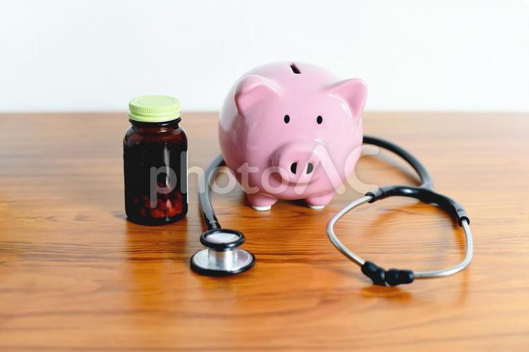 聴診器と貯金箱や医療費や保険料のイメージ 医療費,病院代,薬代の写真素材