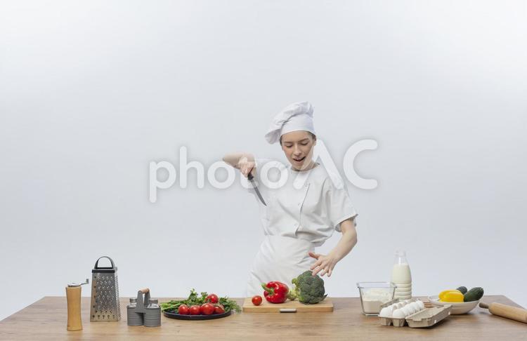 高い位置から包丁でこれからパプリカとブロッコリーを切る女性 女性,シェフ,料理人の写真素材
