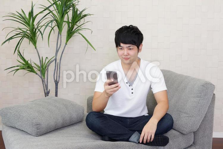 スマートフォンを持つ笑顔の男性 男性,男,スマートフォンの写真素材