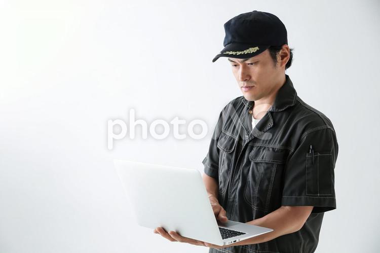 ノートパソコンで仕事する整備士 1人,30代,ftd0011の写真素材