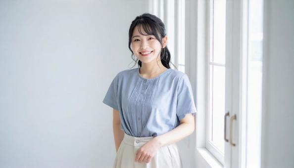 窓際に立つ女性 窓際に立つ女性の写真